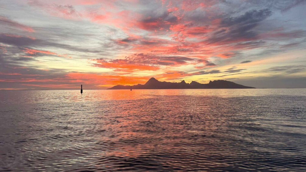 A calm sea at sunset with a sailboat and a buoy. 4