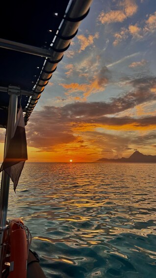 A boat on a body of water during sunset with a mountain in the distance. 3