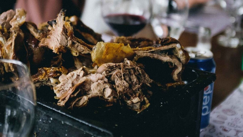A close-up of a charred and burnt food item, possibly meat, on a black surface. 5