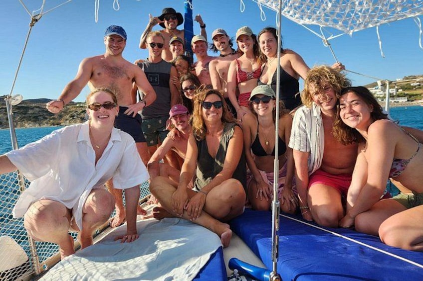Un grupo de personas en un bote frente a un mar azul cristalino y tierra a lo lejos. 5
