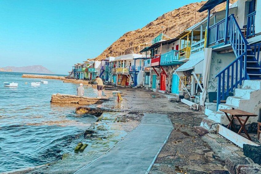 Un villaggio costiero con edifici colorati, una costa rocciosa e barche in acqua. 4