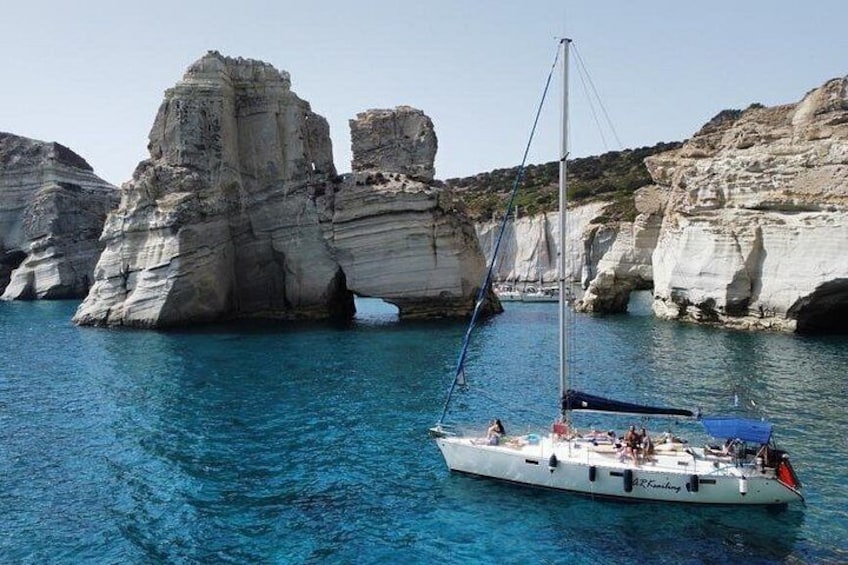 Un velero en aguas azules y cristalinas, con acantilados blancos al fondo. 1