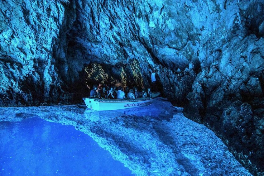 A boat with people on a frozen lake surrounded by rocky cliffs. 1