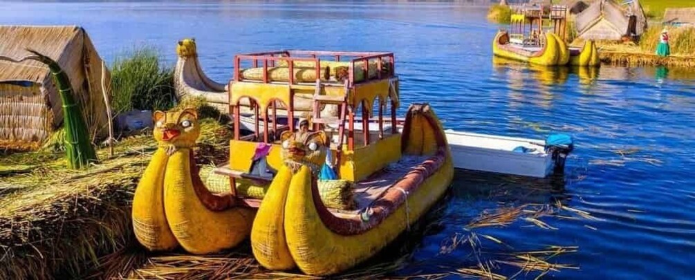 A yellow boat with a cabin, a large yellow sculpture resembling a bird, and a small boat docked nearby. 5
