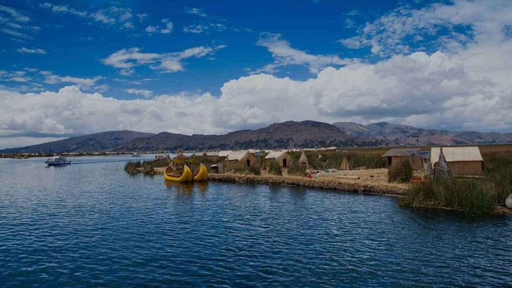 A calm lake with a small boat, yellow canoes, and traditional huts along the shore. 2