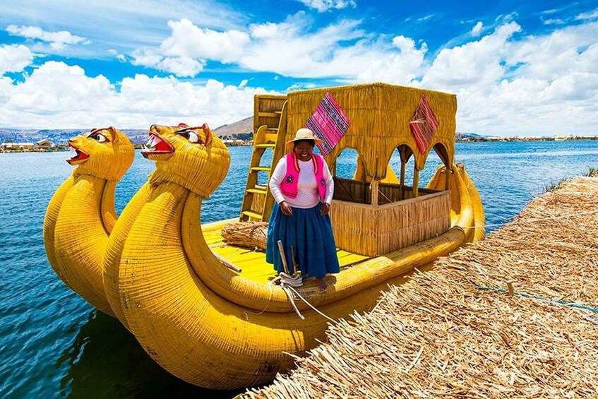 A large yellow boat with a person standing on it, surrounded by water and a clear sky. 3
