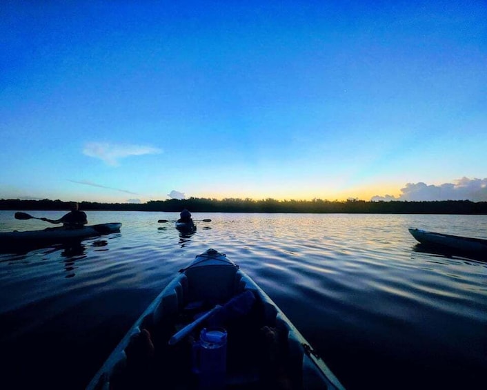 A calm lake at dusk with kayaks and a canoe. 5