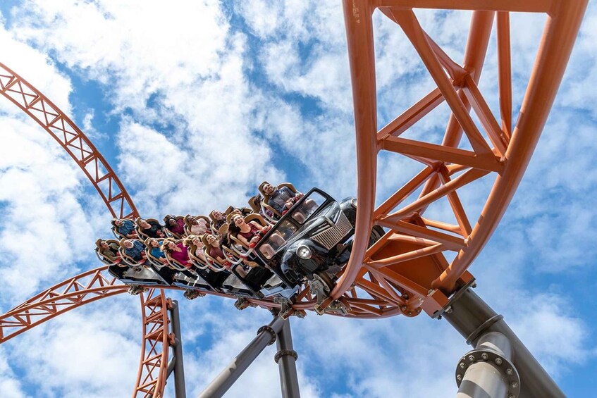 A roller coaster in motion with passengers seated. 1