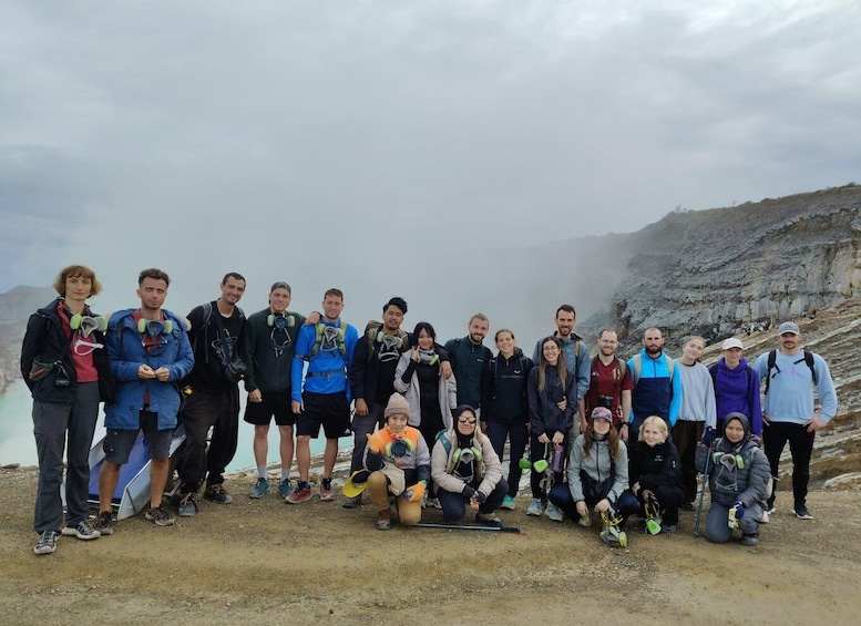 A group of people on a rocky mountain with mist in the background. 1