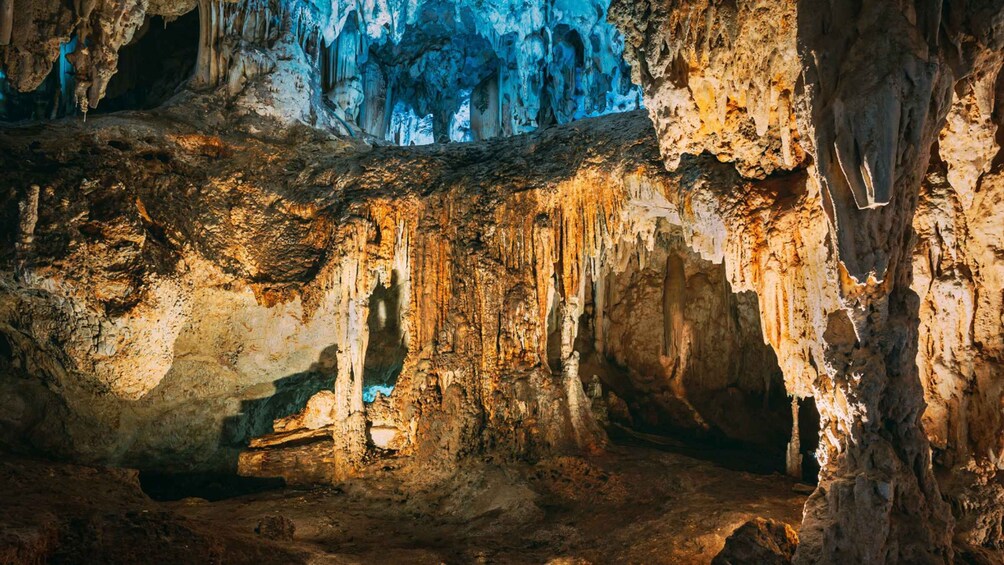 A cave with stalactites and stalagmites, illuminated by artificial lighting. 3