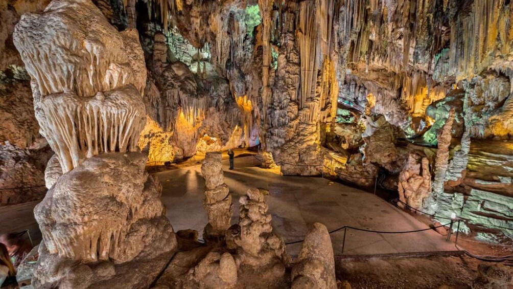 A cave with stalactites and stalagmites, illuminated by artificial lighting. 2