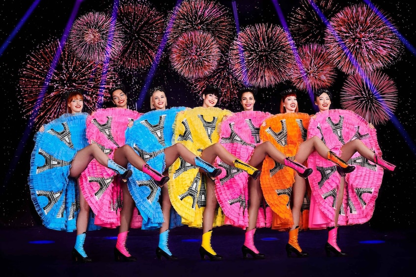 A group of people in colorful costumes with a fireworks display in the background. 5