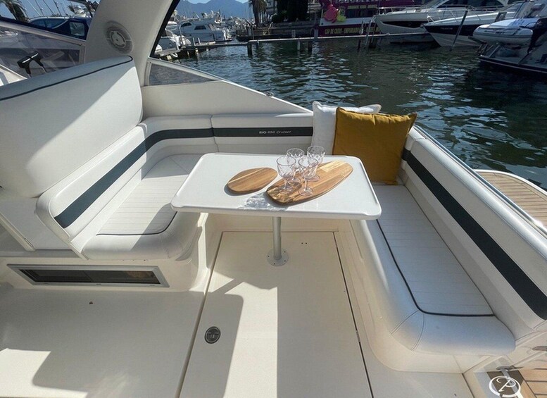 A boat's interior with a table set for two, glasses, and a cushion. 3
