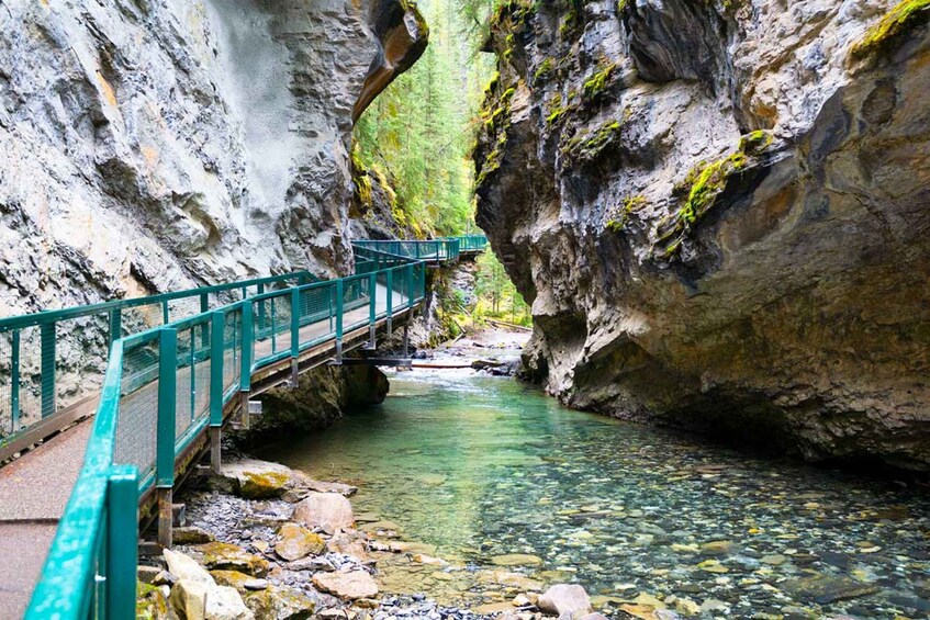 A turquoise bridge over a clear stream in a rocky gorge. 3