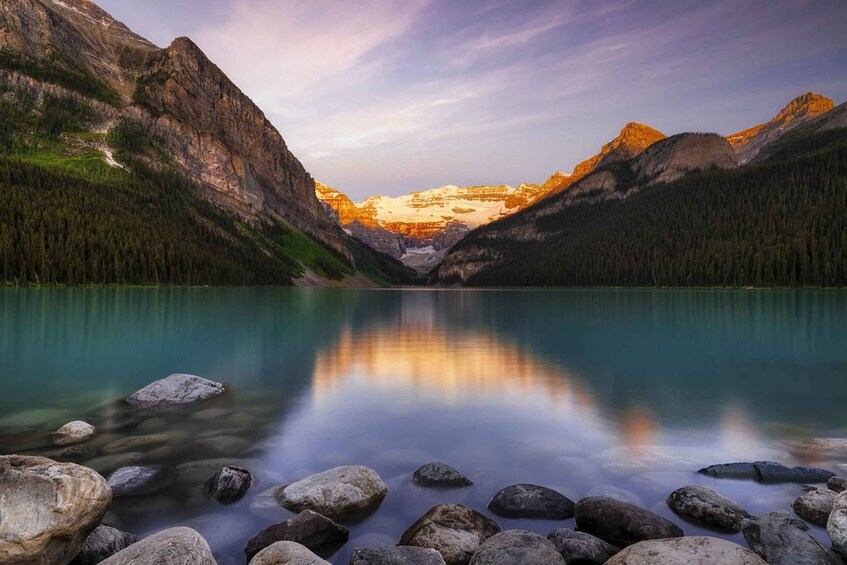 A tranquil mountain lake with clear reflections, surrounded by steep cliffs and dense forests. 1