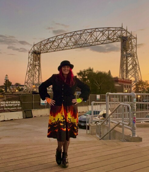 A person standing on a wooden deck with a metal structure in the background. 3