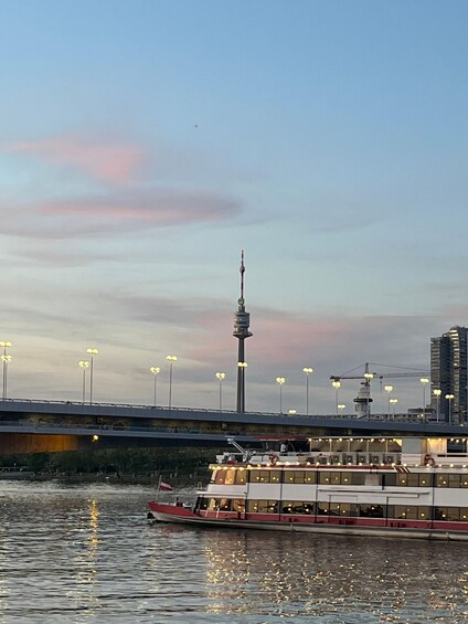 Un río con un bote, un puente y una torre al fondo. 2