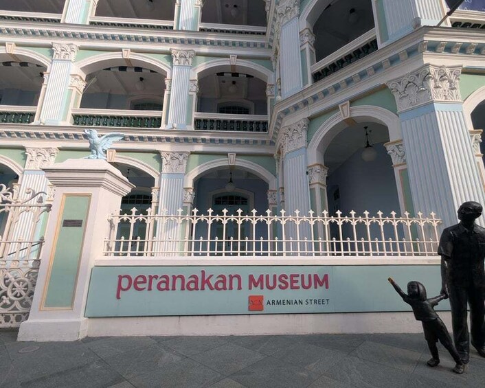 The Perananakan Museum with classical architecture and a statue of a child. 2