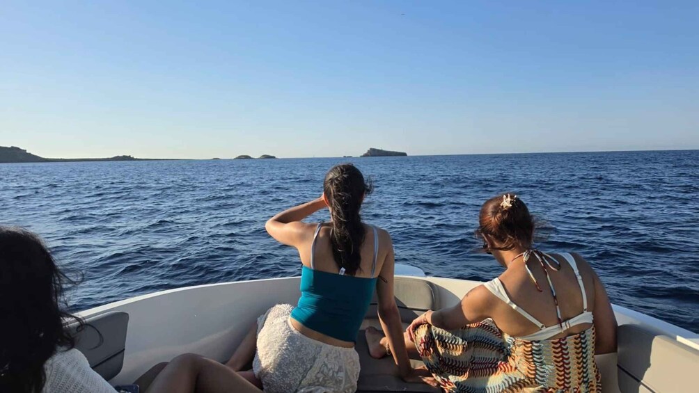 Two people on a boat in the ocean, with calm water and distant islands. 5