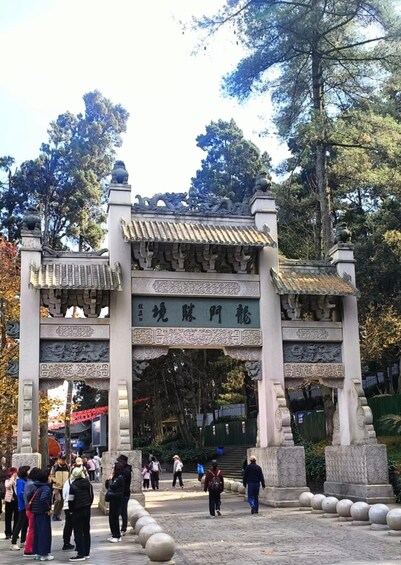 A traditional gate with intricate carvings and a sign with Chinese characters. 5