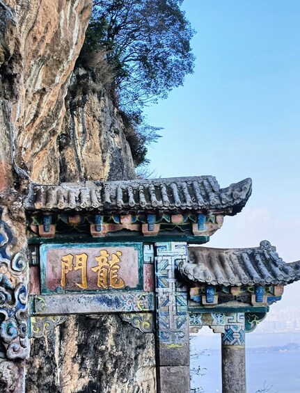 A traditional Chinese gate with intricate carvings and a sign with Chinese characters. 4