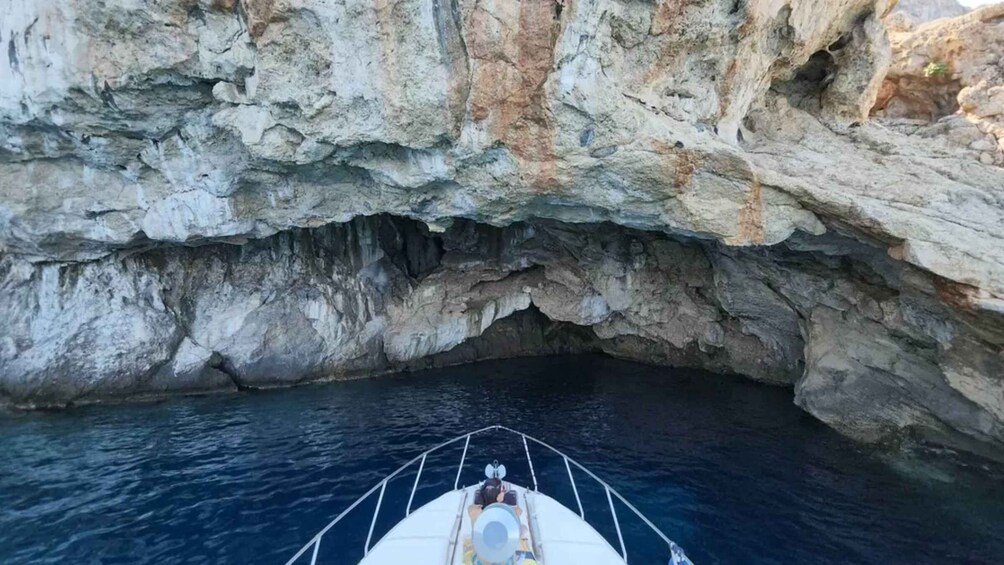 A boat navigating through a rocky cave entrance. 4