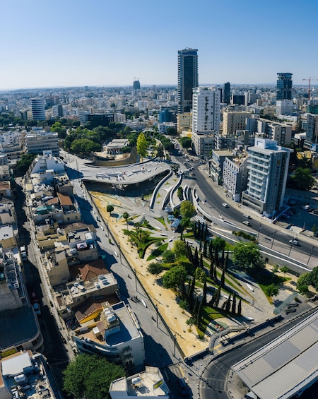 A cityscape with modern buildings, a curved road, and a clear blue sky. 3