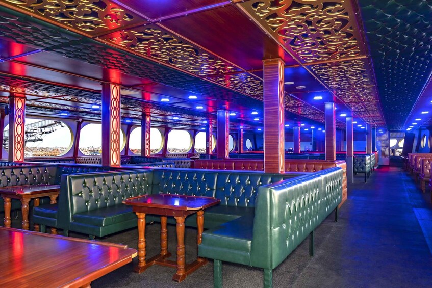 A train dining car with green upholstered seating and wooden tables. 3