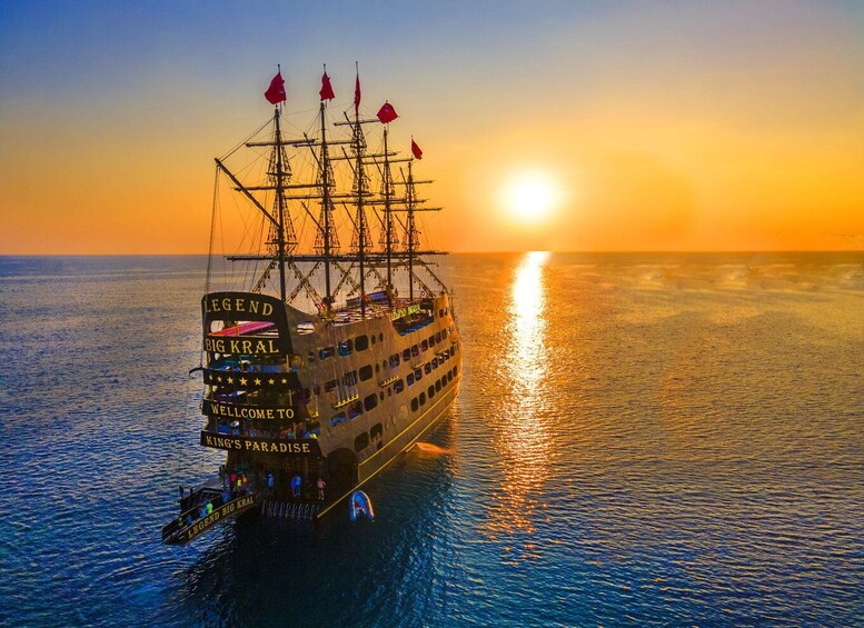 A large ship named LEGEND BIG KRAL sailing on calm waters during sunset. 1