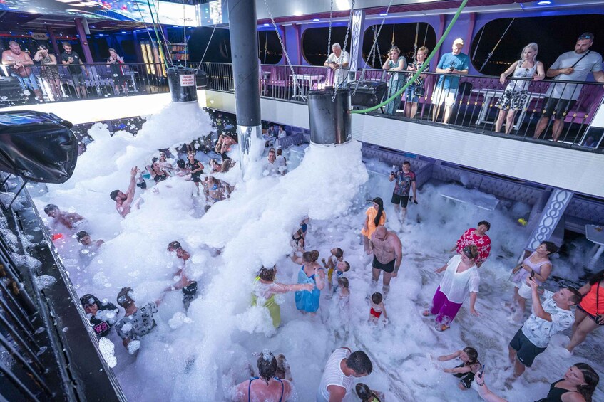 A crowded indoor event with people enjoying a water feature. 4