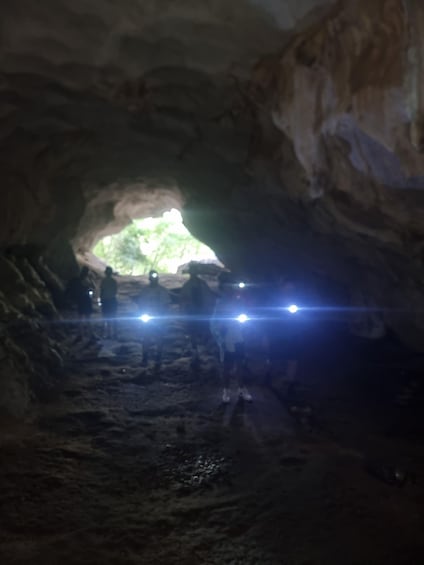 A cave entrance with a narrow passage leading to a brighter area. 3