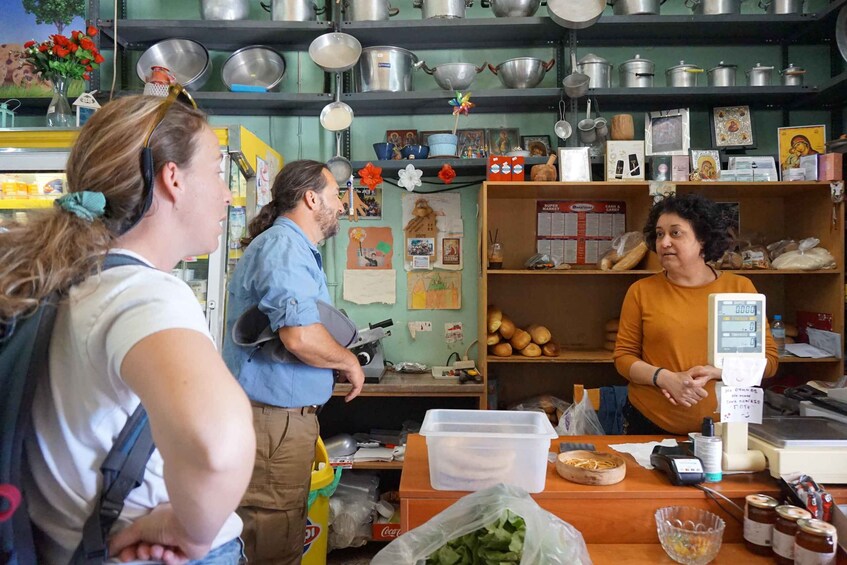 A kitchen with shelves of pots, a cash register, and various food items. 4