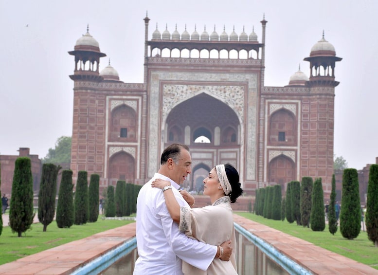 A couple embracing in front of the Taj Mahal. 1