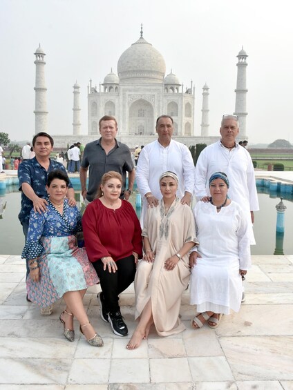 A group of people posing in front of the Taj Mahal. 2