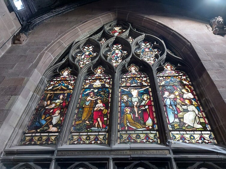 Une vitre décorée de motifs en vitrail représentant des scènes religieuses et portant une inscription commémorative. 3