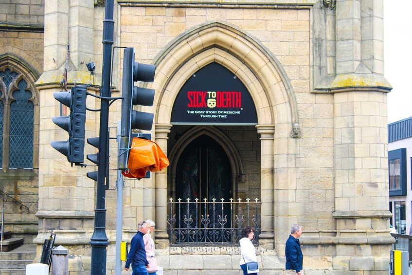 Un bâtiment historique sur lequel on peut lire l’inscription suivante : « RAS-LE-BOL, MAIS QUELLE HISTOIRE ! L’histoire glorieuse de la médecine à travers les âges. » 5