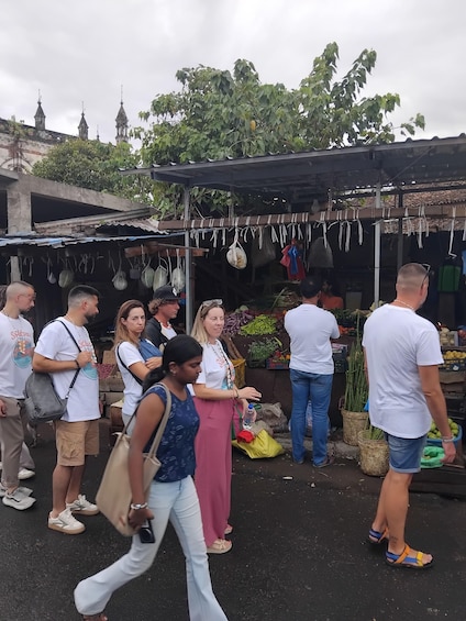 A market scene with people shopping and vendors selling goods. 4