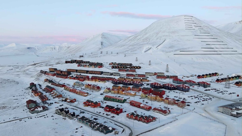 A snowy town with buildings and a train track. 1
