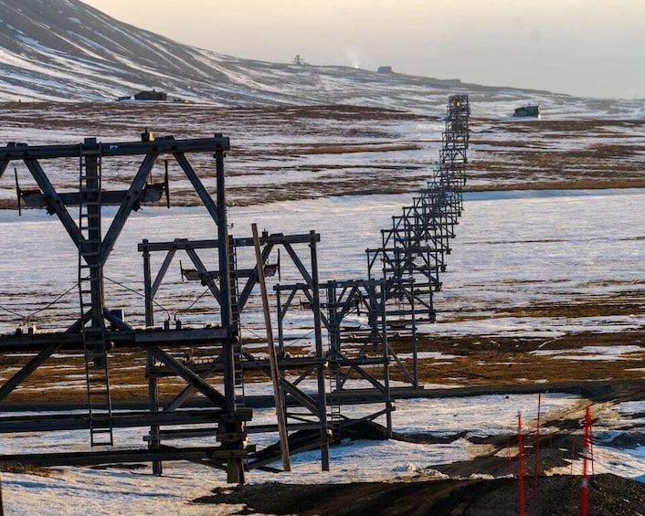 A metal structure in a snowy landscape with a distant mountain. 3