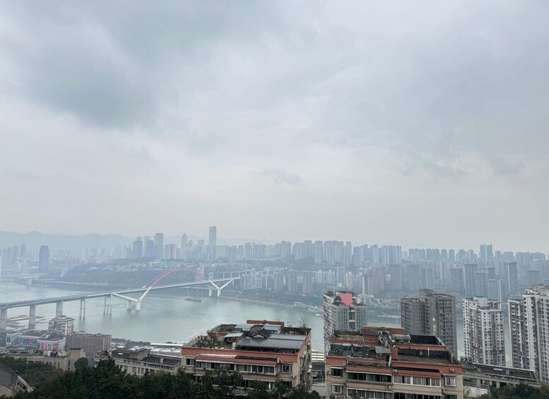 A cityscape with a river, a bridge, and high-rise buildings. 1