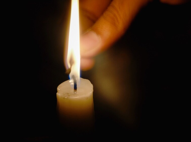 Eine Hand hält einen Streichholz mit einer brennenden Flamme. 3