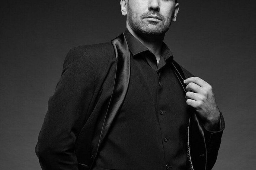 A person wearing a dark suit jacket and shirt. 2