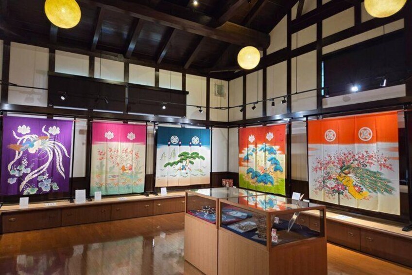 A traditional Japanese room with tatami flooring, shoji screens, and a display of colorful kakebukuro (wooden sliding doors). 1