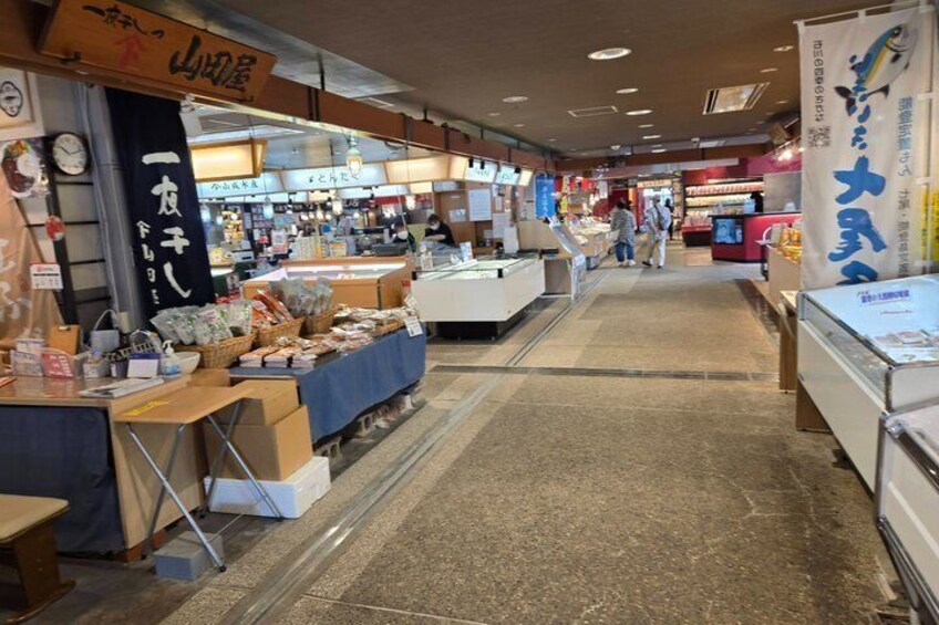 An indoor market with various stalls and a central walkway. 5