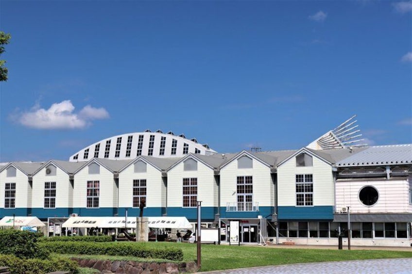 A large, multi-story building with a curved roof and a circular window on the right side. 2