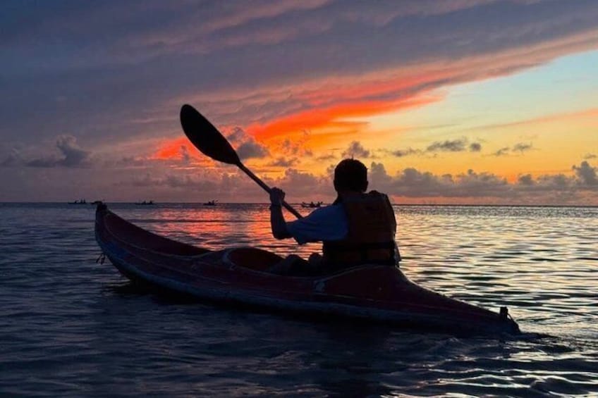 A person kayaking at sunset with a vibrant sky. 1