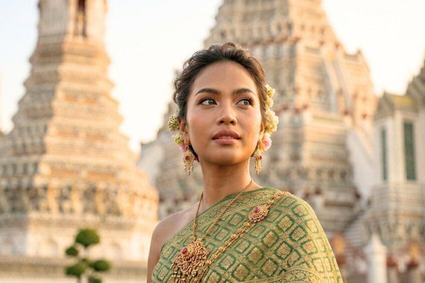 A person in traditional attire with a temple in the background. 2