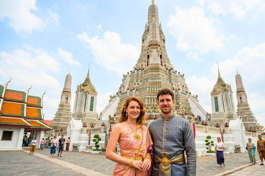 A couple standing in front of a grand temple with intricate architecture. 3