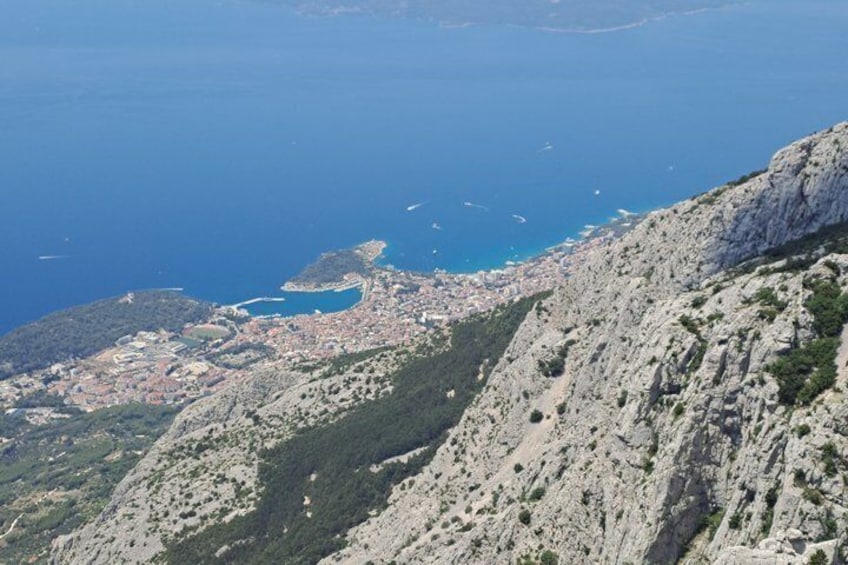 A coastal city with a mountainous backdrop and a clear blue sea. 3