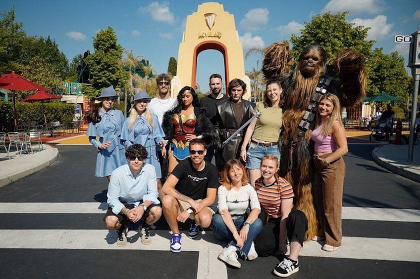 Un grupo de personas posando frente a un monumento con un arco distintivo. 1
